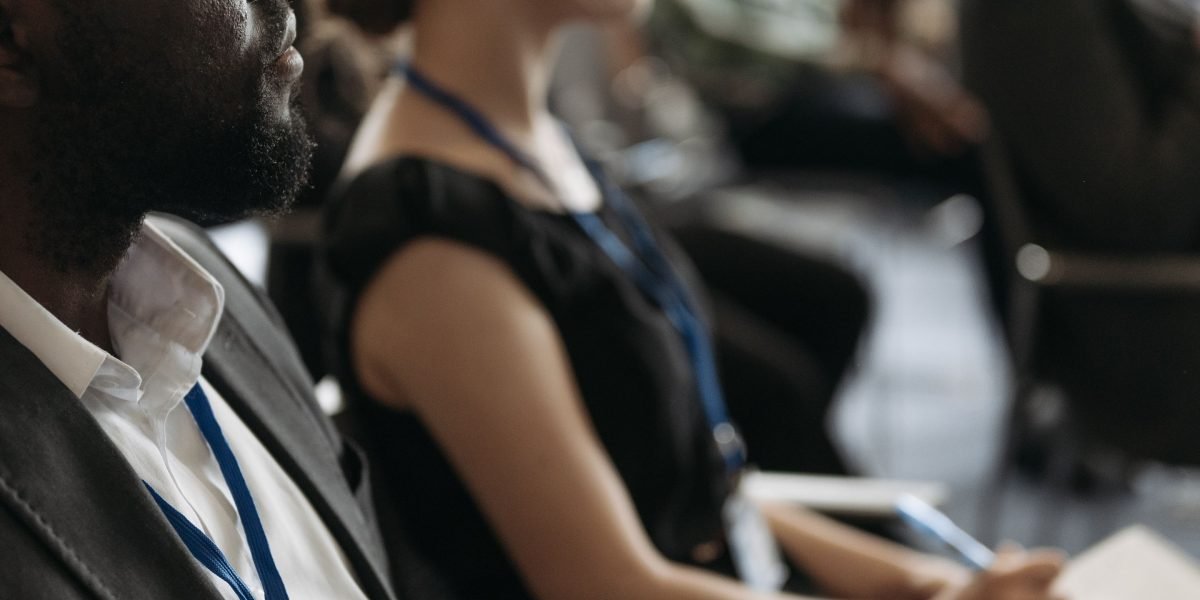 An individual intently listening during a client meeting, emphasizing the importance of understanding customer needs for effective marketing.