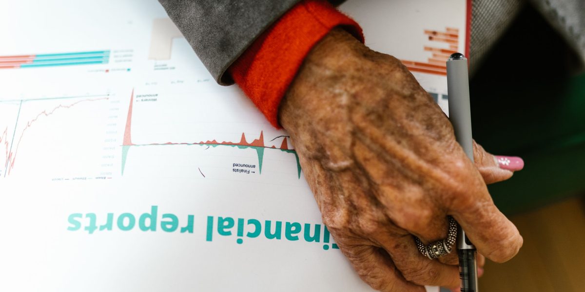A small business owner meticulously reviews financial documents and marketing reports, assessing costs against potential returns.