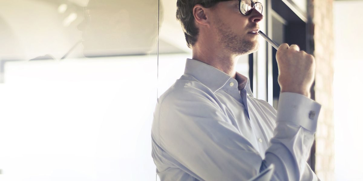 A small business owner in a thoughtful pose, contemplating strategic decisions for their company's online growth.