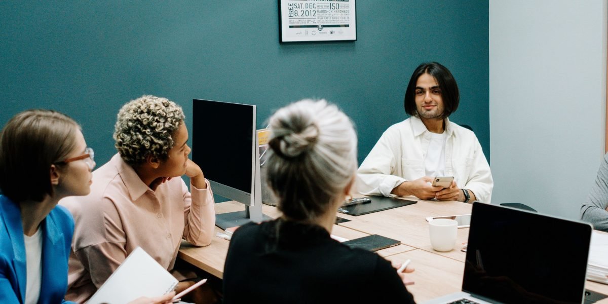 A team of professionals actively collaborating to define clear business goals and performance targets on a whiteboard.