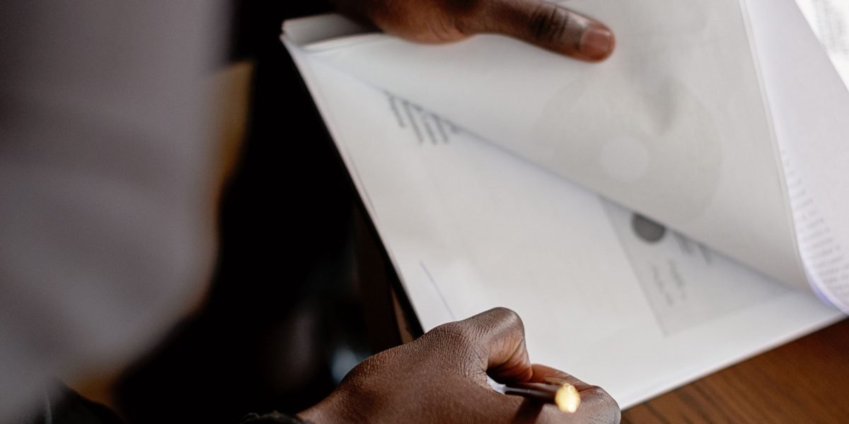 A person intently reading and reviewing a document, emphasizing the importance of thorough contract examination.