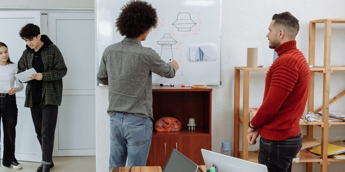 A team collaborating around a whiteboard, sketching out ideas and discussing potential designs for a new website prototype.