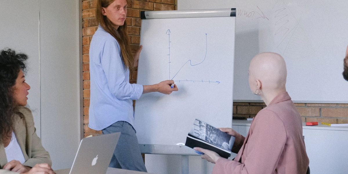 A team collaborating around a whiteboard, outlining a clear, step-by-step plan for a small business website project.