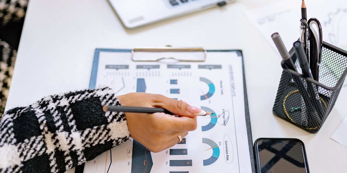 A person reviews financial documents, considering the investment in a UI/UX design education.