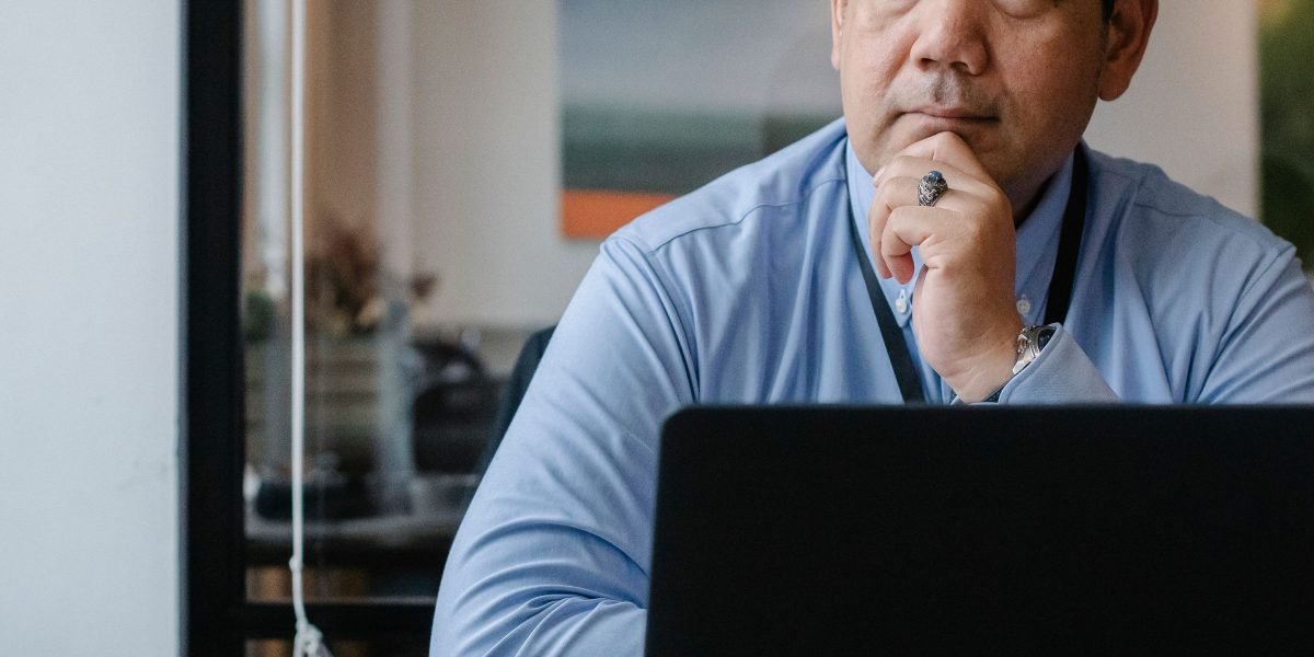 A small business owner thoughtfully reviewing financial documents, seeking growth.