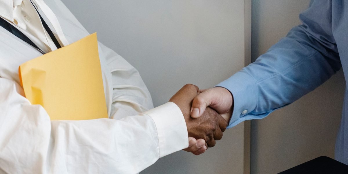 Two professionals shaking hands after a successful meeting, symbolizing a new job opportunity or collaboration.